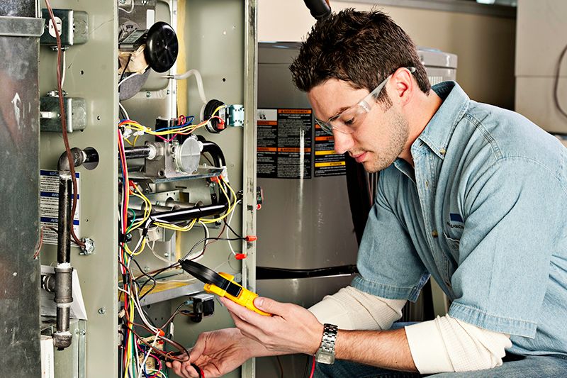 Image of a technician working with AC unit. Why Do I Need AC Maintenance Now?