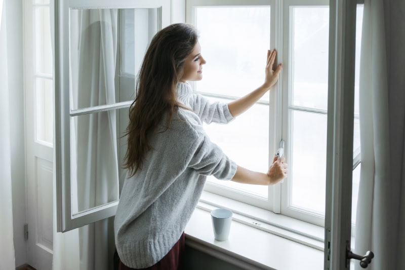 Controlling Humidity in Your Home. Women at window.